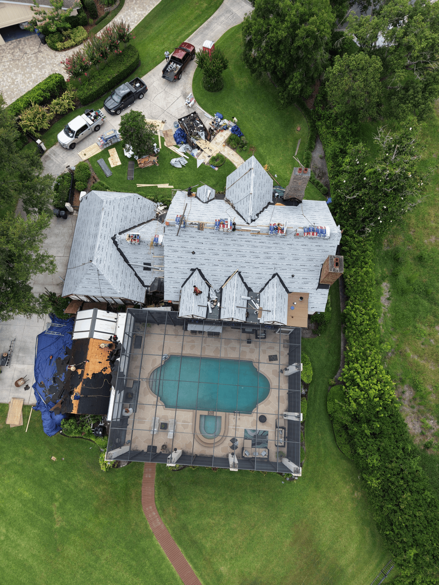 Roofer inspecting wet roof underlayment and water-damaged roof decking on a Florida home